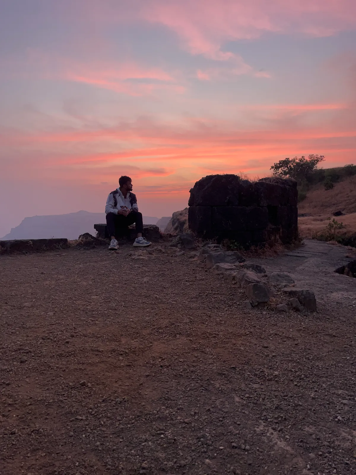 A pink sunset over a cliff edge